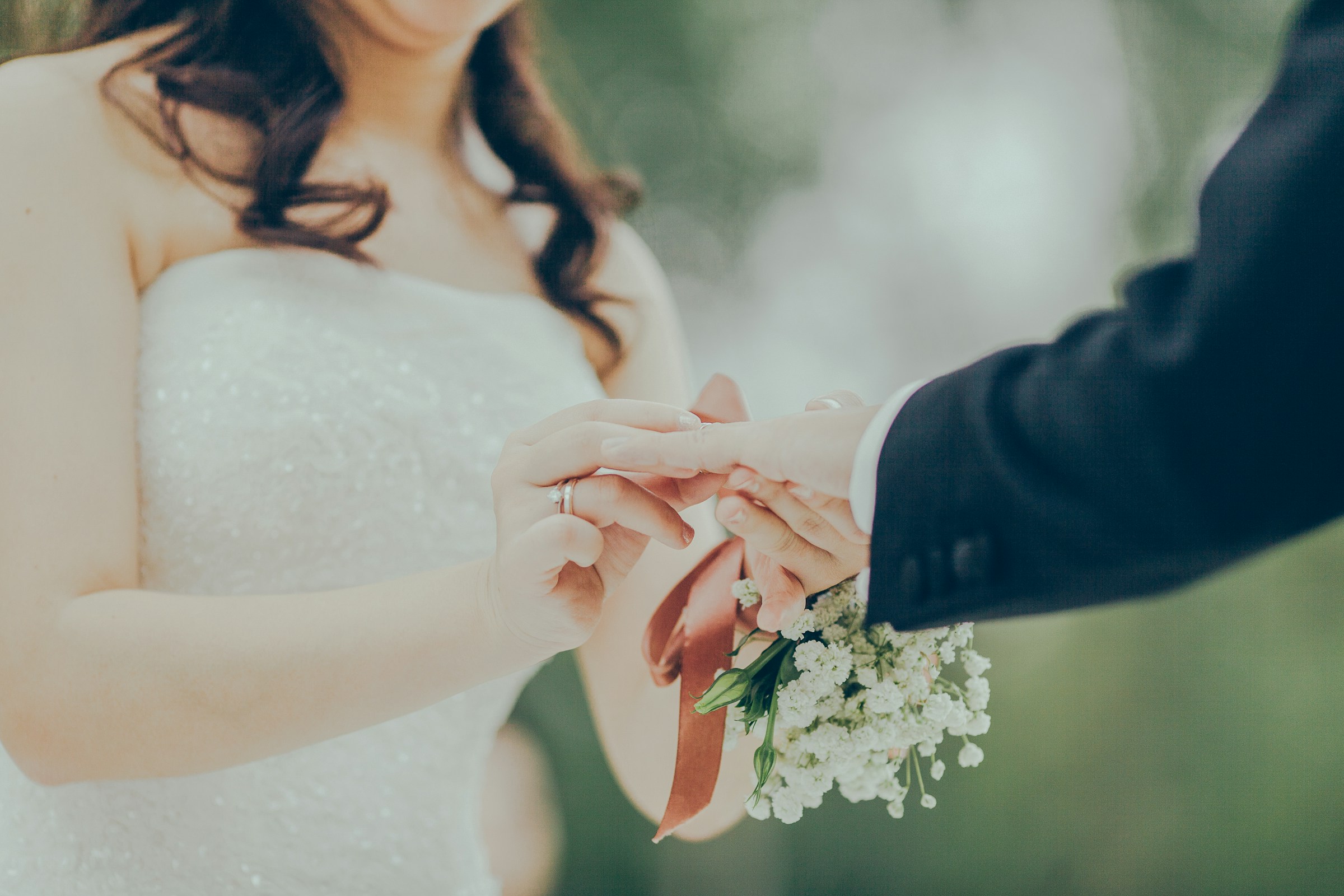 A bride putting on the groom's wedding ring | Source: Unsplash